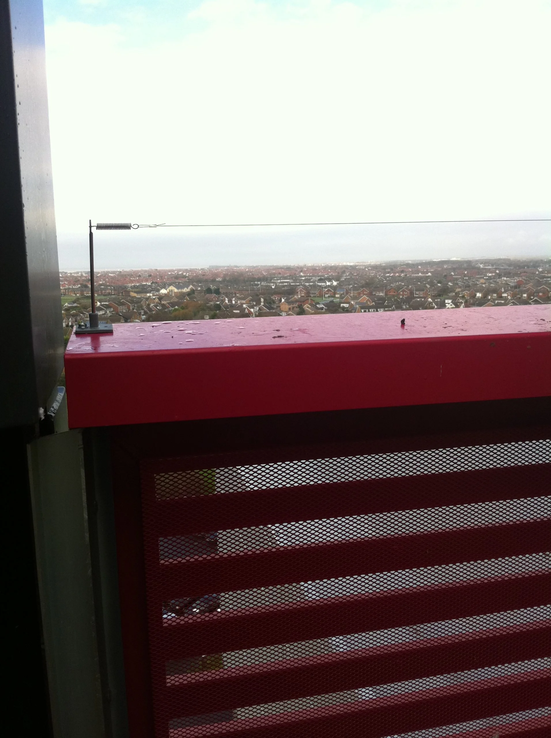 Tensioned bird wire running along a building parapet on the D and B Facades building